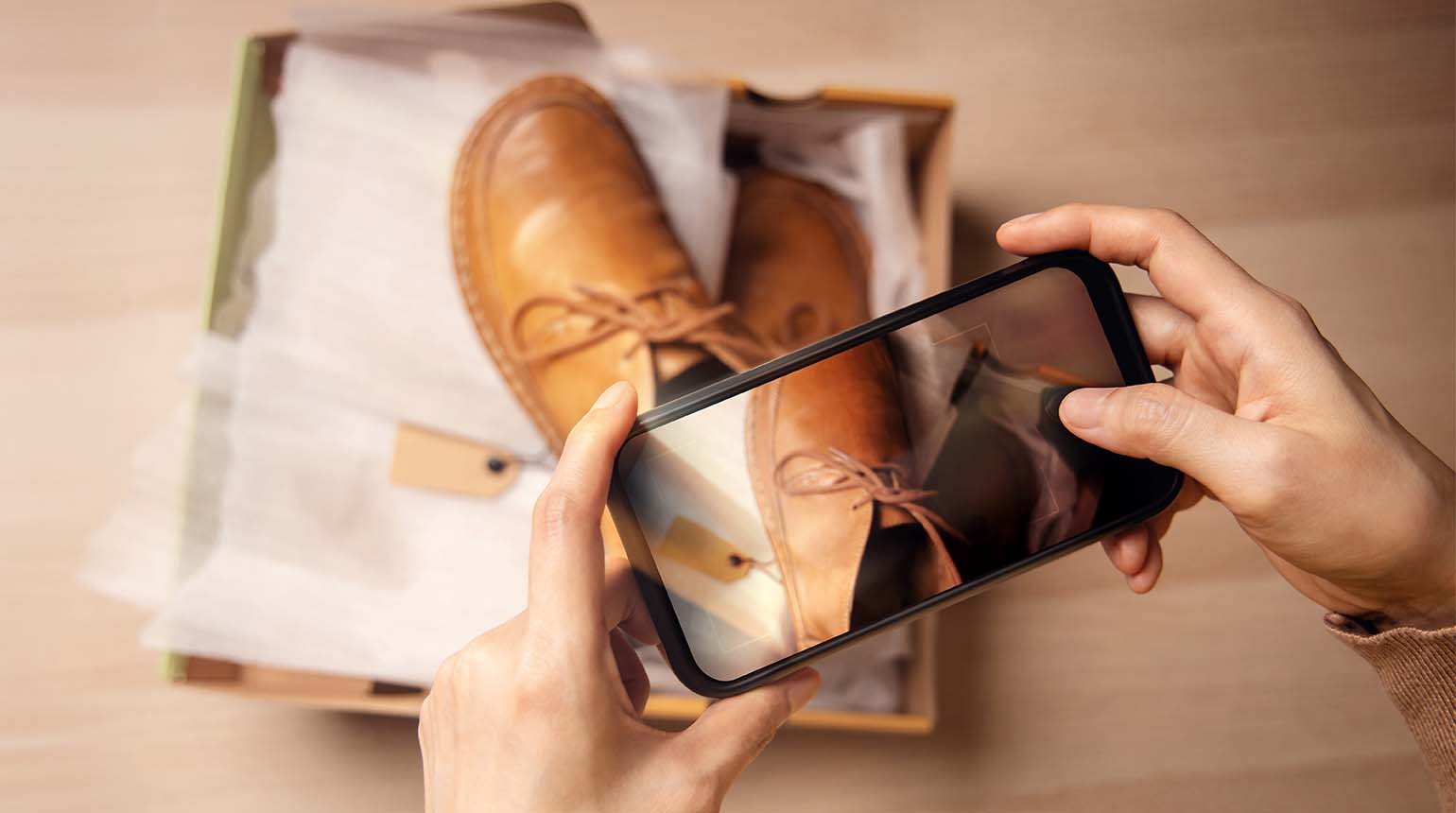 Man taking a picture of his shoes in a delivery box to resell online