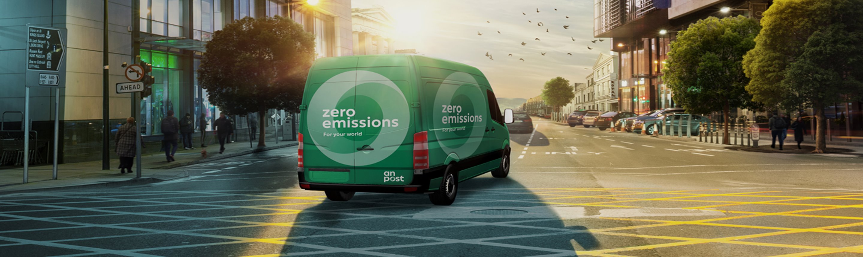 An Post zero emissions vehicle driving through urban street at sunrise