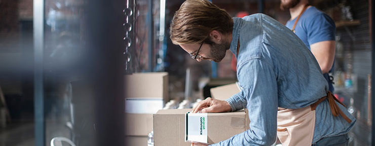 Women and man looking at clothes from a box