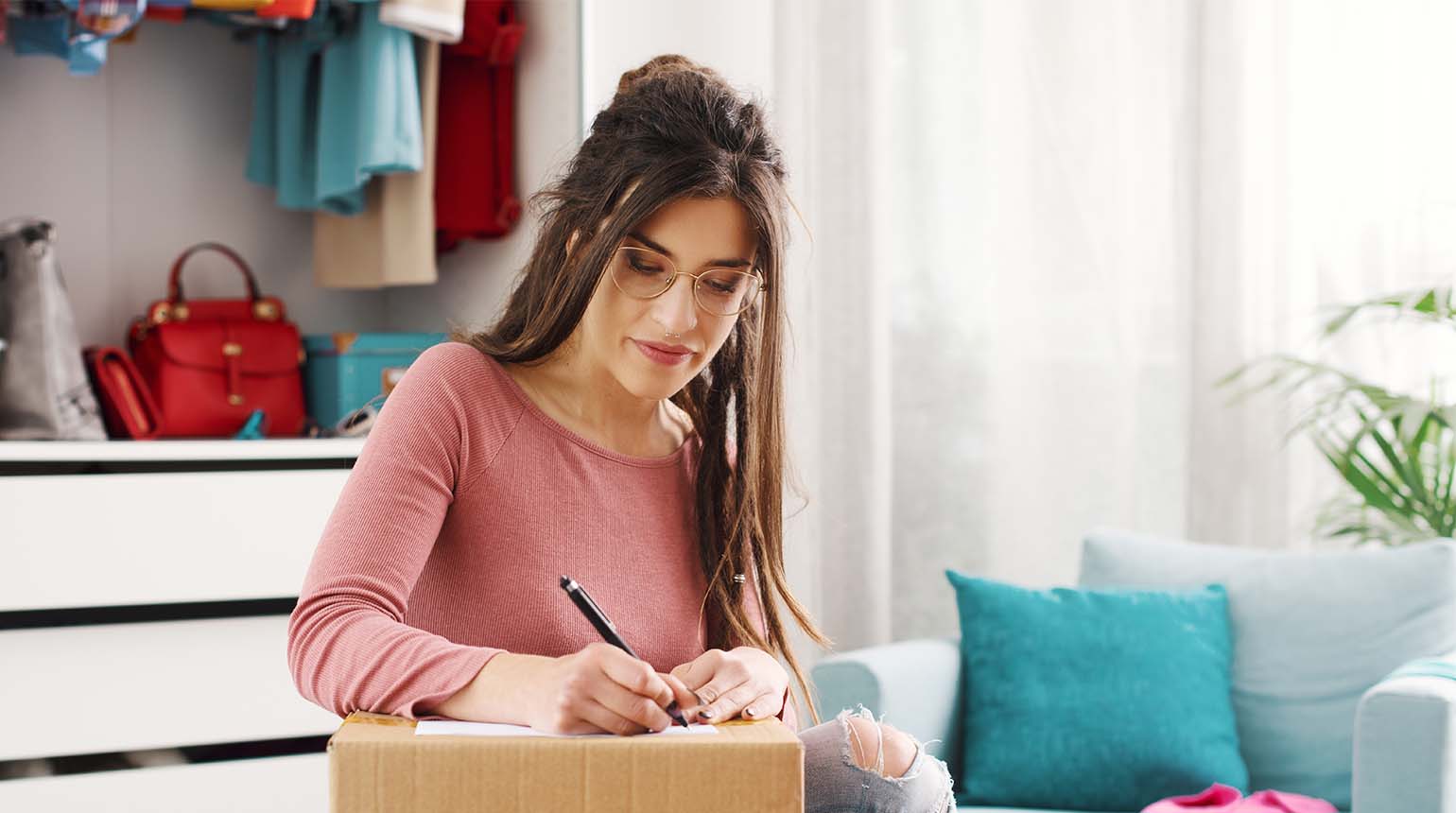 Woman writing a delivery address on a parcel