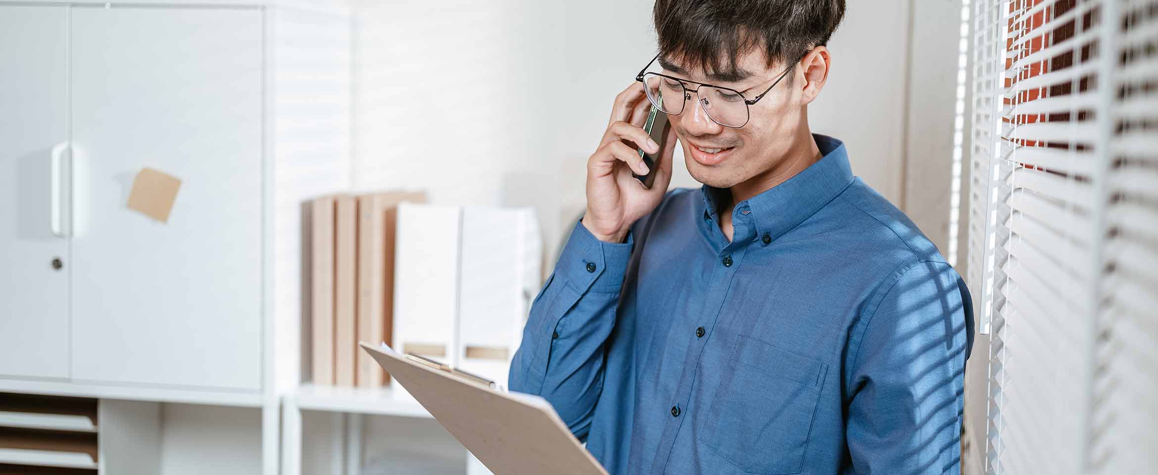 Person reviewing printed communications and mailing requirements, illustrating Print Post services for business mail campaigns.